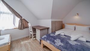 um quarto com uma cama, uma secretária e uma janela em Apartamenty Sun & Snow Kaniówka em Białka Tatrzanska