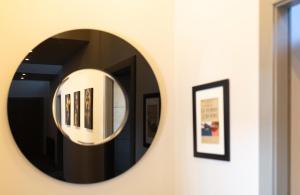 a round mirror on a wall with framed pictures at Luxury Manhattan loft-style apartment near Edinburgh city centre in Edinburgh