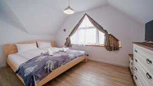 um quarto com uma cama grande e uma janela em Apartamenty Sun & Snow Kaniówka em Białka Tatrzanska