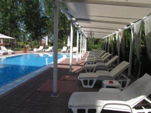 a row of lounge chairs next to a swimming pool at Apartments and studios in Cote d’Azure in Sunny Beach