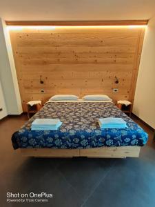 een slaapkamer met een bed met een houten hoofdeinde bij Chalet allemand in Sauze dʼOulx
