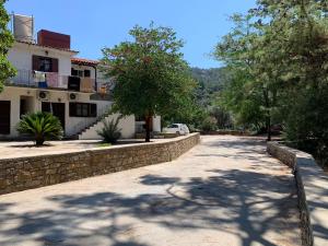 a street in front of a house with a stone wall at One Bedroom Apartment With Kitchenette# 12 A in Raches