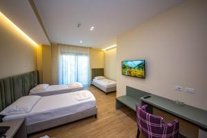 a hotel room with two beds and a flat screen tv at Hotel Bella Vista in Durrës