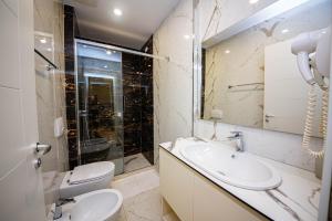a bathroom with a sink and a toilet and a shower at Hotel Bella Vista in Durrës