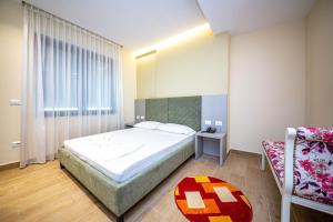 een slaapkamer met een groot bed en een stoel bij Hotel Bella Vista in Durrës