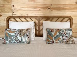 a bed with two pillows and a wooden wall at Sesimbra Natural Room and private access in Sesimbra