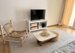 a living room with a chair and a television at Sesimbra Natural Room and private access in Sesimbra
