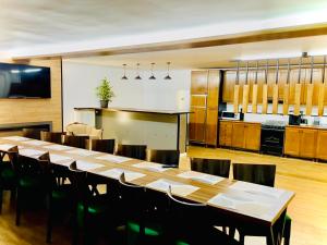 comedor grande con mesa larga y cocina en Valea Putnei Residence- Rooms for rent, en Valea Putnei 13 fotos más