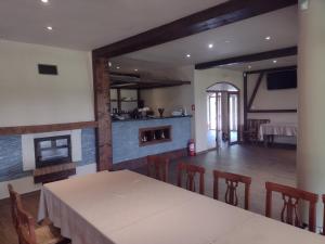 a dining room with a table and chairs and a kitchen at Pensiunea Larysse in Baile Felix