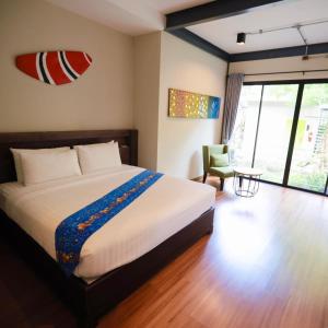 a bedroom with a bed and a chair and a window at Tolopoti Hotel&Resort in U Thong