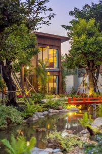 a house with a pond in front of it at Tolopoti Hotel&Resort in U Thong