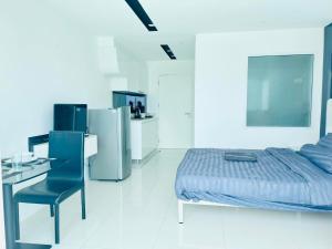a bedroom with a bed and a desk and a chair at City Center Residence Condominium Pattaya RJ in Pattaya Central