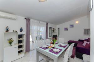 a living room with a table and a purple couch at Apartment Zvonimir in Nečujam
