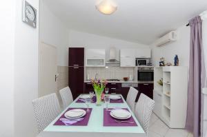 a kitchen with a dining room table with chairs at Apartment Zvonimir in Nečujam