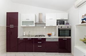 a kitchen with purple cabinets and a sink at Apartment Zvonimir in Nečujam