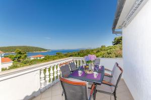 a table on a balcony with a view of the ocean at Apartment Zvonimir in Nečujam