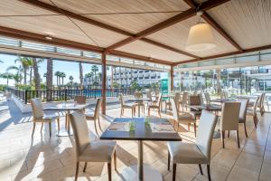 a restaurant with tables and chairs on a patio at Barceló Cabo de Gata in Retamar