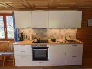 a kitchen with white cabinets and a sink at Ferienhaus Vakanz in Raggal +28 photos