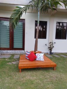un banco de madera sentado en el césped frente a una casa en Happy's Homestay en Boracay