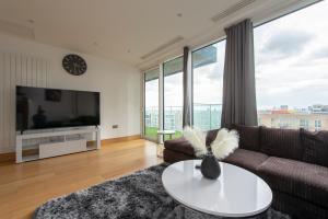 a living room with a couch and a tv at Lovely 2-Bed luxury Apartment in city of London in London