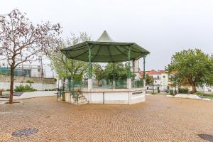 a gazebo with a green umbrella on a street at Vita Portucale ! Cacilhas River View in Almada