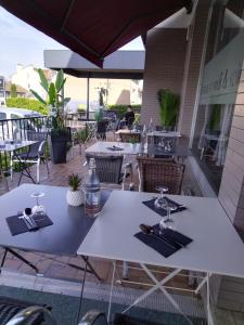 - une table blanche avec des verres et des serviettes sur une terrasse dans l'établissement Le Relax, à Aurillac