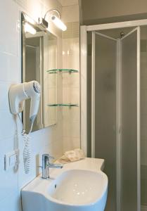 a bathroom with a white sink and a shower at Hotel Mirage in Viareggio