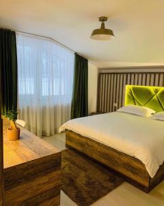 Un dormitorio con una cama grande y una ventana. en Valea Putnei Residence- Rooms for rent, en Valea Putnei