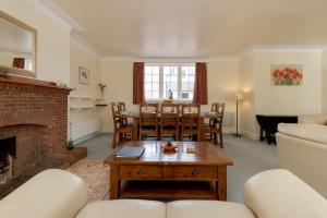 Balcraig House في Maybole: غرفة معيشة بها موقد وطاولة وكراسي