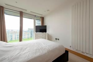 a bedroom with a bed and a large window at Lovely 2-Bed luxury Apartment in city of London in London