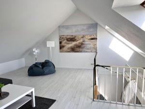 a white living room with a large painting on the wall at Ferienhäuser Insel Usedom Haus Samara 8 - Blick aufs Achterwasser! Whirlpool und Sauna in Lütow