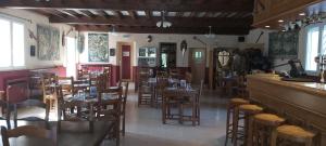a restaurant with wooden tables and chairs and a bar at Auberge le Cévenol in La Cavalerie