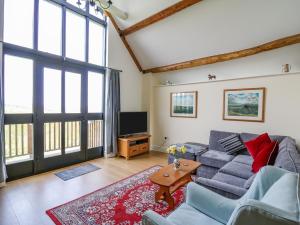 a living room with a couch and a tv at Goblaen Barn in Builth Wells