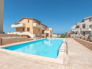 a swimming pool in front of some buildings at CASTELSARDO- Elegante Appartamento vista Mare in Castelsardo