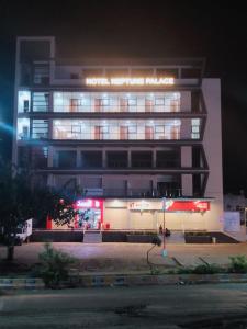 ein hohes Gebäude mit Lichtern in der Nacht davor in der Unterkunft Hotel Neptune Palace in Anand