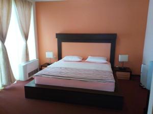 a bedroom with a large bed with two pillows at Hotel Lukavac in Lukavac