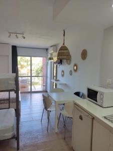 a kitchen with a table and chairs and a microwave at Apartamento Minerva Jupiter. The perfect accommodation for your vacation in Benalmádena