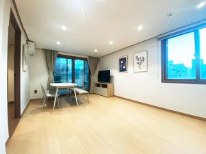 ein Wohnzimmer mit einem Tisch und einem TV in der Unterkunft Luxe & Suite Room in Seoul