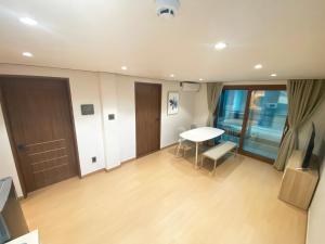 Zimmer mit einem Tisch und einer Tür sowie einem Tisch und Stühlen in der Unterkunft Luxe & Suite Room in Seoul