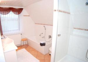 uma casa de banho branca com uma banheira e um chuveiro em FW Hannelore em Grossenbrode