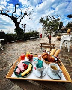 uma bandeja de comida com pão e café numa mesa em Hôtel Astria em Le Lavandou