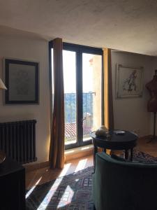 a living room with a large window and a chair at Derrière l'église in Saint-Paul-de-Vence