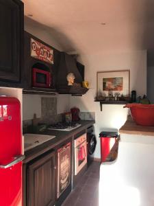 a kitchen with a red stove and a microwave at Derrière l'église in Saint-Paul-de-Vence