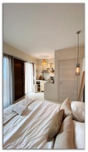 a large white bed in a room with a kitchen at Casa Del Mar Thassos in Skala Sotiros