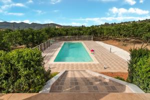 an empty swimming pool in a field with trees at Villa Rosemagnolia, pool 35m2, in green, gardens, full sun close to everything in Ayiá