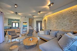 a living room with a blue couch and a stone wall at Luxury Villa Ebellina by PosarelliVillas in Acharavi