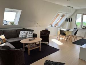 ein Wohnzimmer mit einem Sofa und einem Tisch in der Unterkunft Apartment Ruhetgaard Bed & kitchen in Ærøskøbing