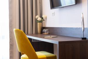 a desk with a yellow chair in a room at Villa Fortis B&B in Trogir