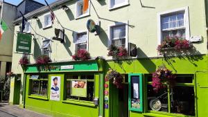 un edificio verde con dei fiori sul lato di The 'Rafter's Gastropub a Kilkenny