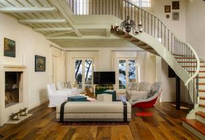 Luxury Villa Brač Pearl by Irundo في بول: غرفة معيشة بها درج مع أريكة وكراسي